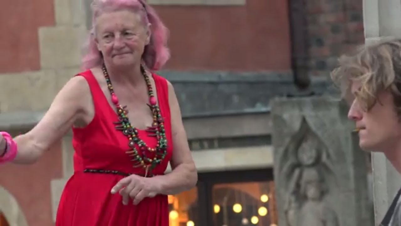 Old and drunk woman dancing in the street