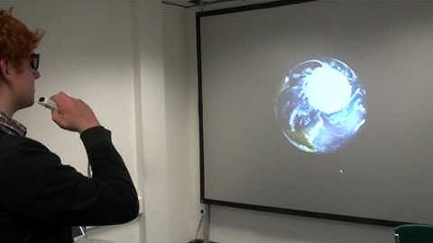 Liam using a Wii remote to manipulate a 3-D map of the Earth.