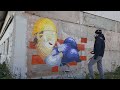 Spray painting a graffiti character for a construction company