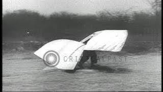 A man with huge cardboard wings strapped to his back jumps off a rock and falls o...HD Stock Footage