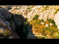 Dolly zoom. Goreme, Nevsehir, Turkey. Overhead drone view of a narrow, verdant gorge with towerin...