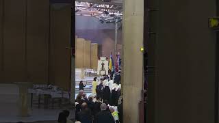 Catholic procession at the Sanctuary of Our Lady of Lourdes, a smaller church next to it.