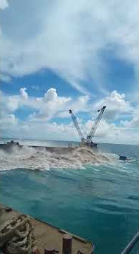 Tongkang muatan kayu log kebalik di tengah laut.