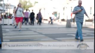 Footage. People walk along a street where a lot of people