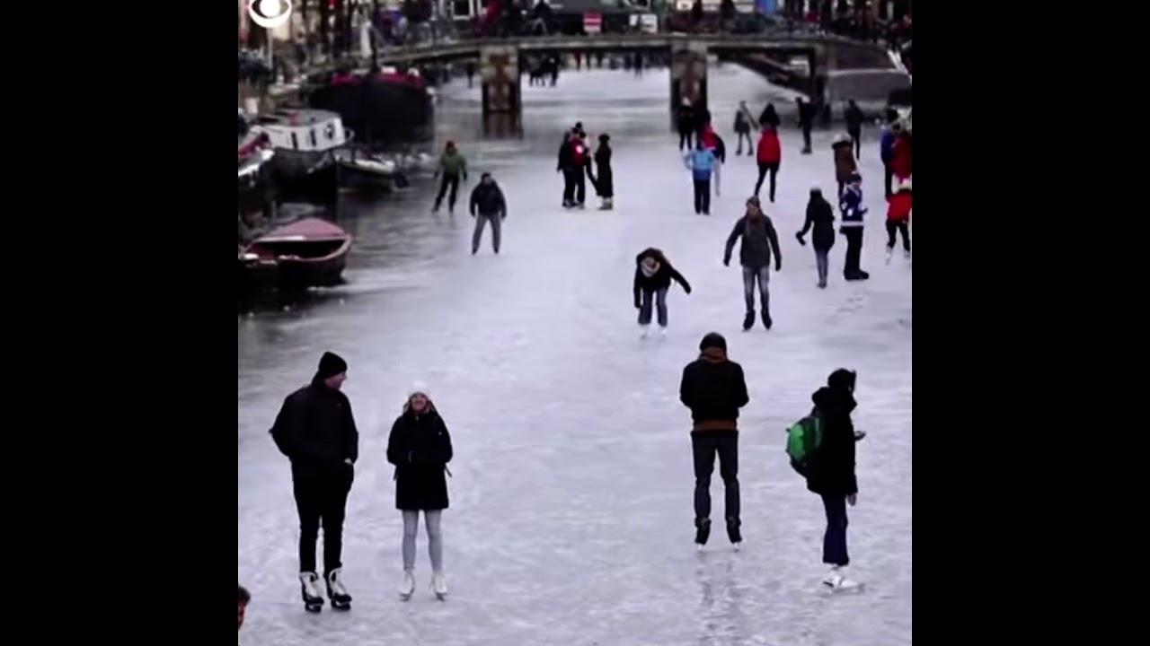 People are skating down  Frozen Canals in The Netherlands