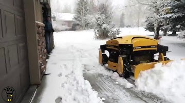Man Shovels Snow Using Remote Controlled Snow Plow Machine
