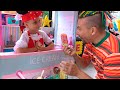 Alicia está jugando en la heladería para niños con papá y haciendo helados saludables