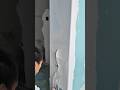 A worker is applying and smoothing plaster on a wall surface