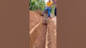 Farm Workers Operating a Powerful Trenching Machine to Dig Deep Furrows in the Field with Precision