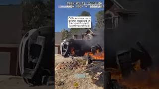 Officers rescue a driver trapped in her overturned burning vehicle