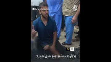 فلسطيني يقرأ آيات من القرآن بجوار والده الشهيد في غزة