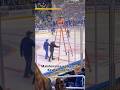 Maintenance workers at KeyBank Center push a tall ladder across the ice to do some repairs
