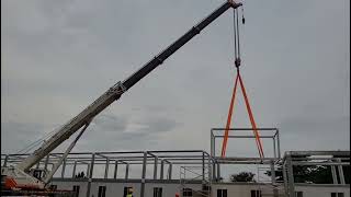 Mobile crane qy70v zoomlion at a construction site | prefab frame container house 20ft installation