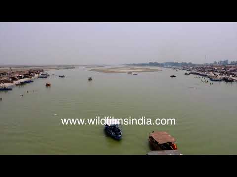 Small boats carry visitors across the wide Ganga near the busy riverside ghats of Haridwar