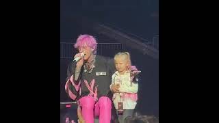 Mgk live on stage with a little girl with a custom shirt. She melted his heart