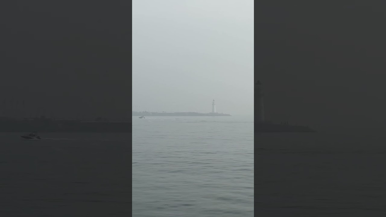 Вид на маяк в тумане с набережной в Циндао / View of the lighthouse in the fog  in Qingdao 