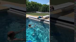 Little boy attempts to dive into pool but falls on diving board and flips forward