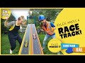 Kylee makes a race track  handyman hal and kylee build a racecar track and race toy cars for kids