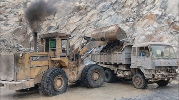 Powerful Caterpillar 966E Wheel Loader Loading Giant Rocks into Mitsubishi Dump Trucks