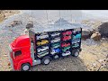 川辺で赤いトラックに17種類のミニカーを乗せた。At the riverside, I put 17 kinds of miniature cars on a red truck.