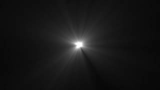 bright white lens flare with light rays and dust particles on black background for overlays & effect