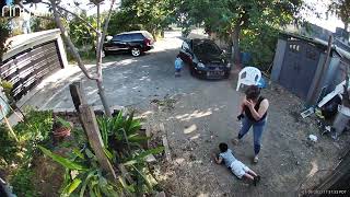 Gust of wind moves back gate that hits little boy on back (Security camera) (Angle 2)