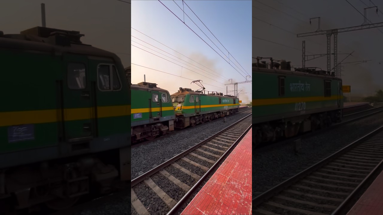 Double engine passing goods train with station beautiful views