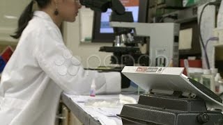 Bidirectional Rotator Rocks While Lab Technician Works In Background 2 Of 2. Stock Footage