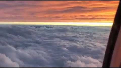 Plane flying between two layers of clouds