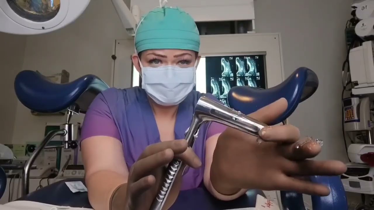 Brown Ansell Gammex latex sensitive surgical gloves and reviewing a speculum.