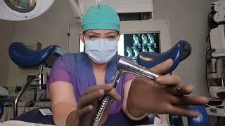 Brown Ansell Gammex latex sensitive surgical gloves and reviewing a speculum.