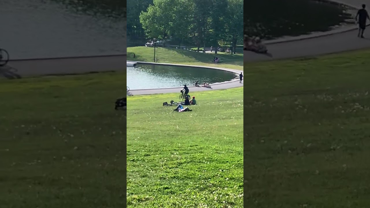 Guy rides bike down grass hill into water