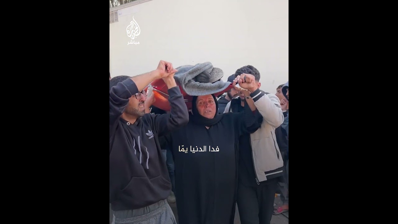 فلسطينية تحمل نعش نجلها الشهيد