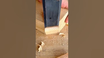 Woodworker using a wide chisel to clean and define a rabbet or dado joint in wood