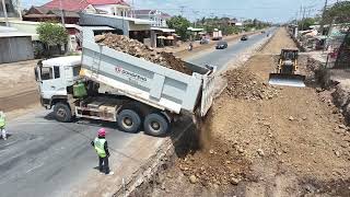 : Massive Rock Loading Dump Trucks Are Removed From Construction Using Skill Work Dozer SHANTUI SD22