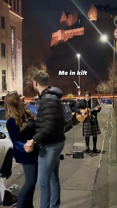 Singing Little Bit More to the newly weds, in a kilt, under a castle