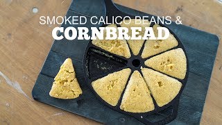 Smoked calico beans and cornbread in a cast iron skillet, highlighting a baking recipe for Green Mountain Grills.