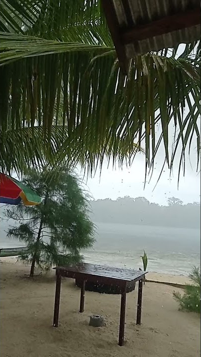 pemandangan pantai saat hujan deras