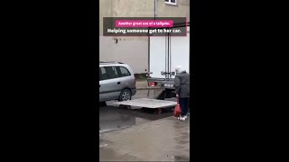 Woman finds car in the middle of a flooded street. Truck to the rescue!