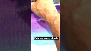 Painting moody clouds on a purple sky.