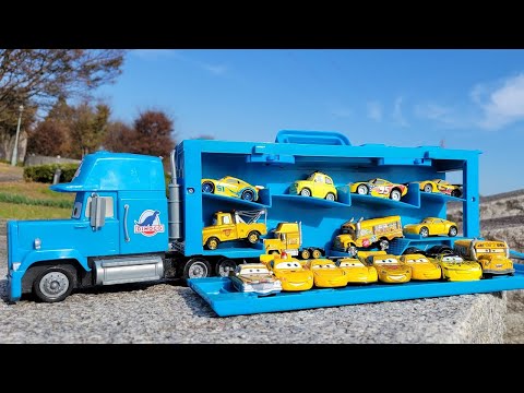 16 bright yellow cars minicar (Tomica) & blue king trailer｜In a park with a lot of dead leaves