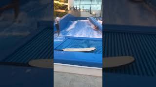 Girls rides boogie board on flow rider and flips over