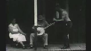 Roscoe Holcomb - 1962 interview + playing banjo to man dancing on porch and dogs playing by well