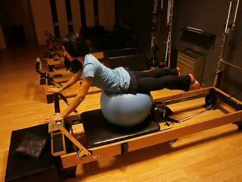 Ejercicio de pilates con pelota sobre reformer | Rebeca Ludman
