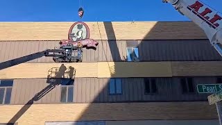 Crews work to remove Aunt Millie’s signage from Pearl Street building