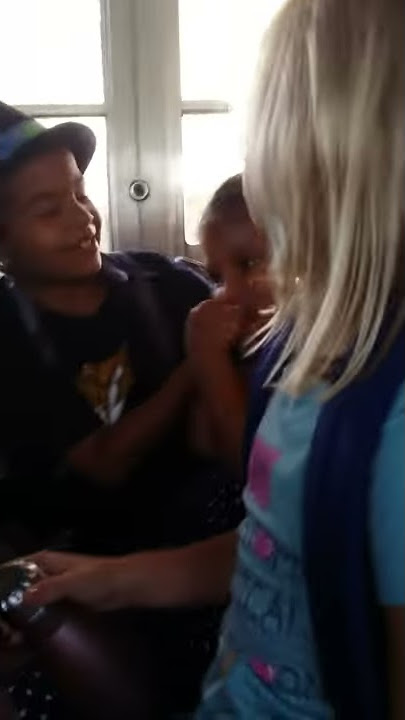 A brother kissing her sister in a school bus