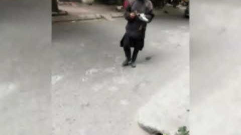 Hình ảnh người mặt đen đồ đen cầm đầu gà đi xin tiền