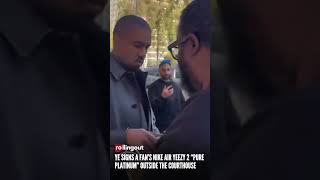 Ye signs a fan’s Nike Air Yeezy 2 “Pure Platinum” outside the courthouse
