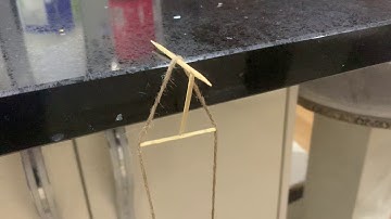 Holding up a water bottle with 3 toothpicks and a piece string