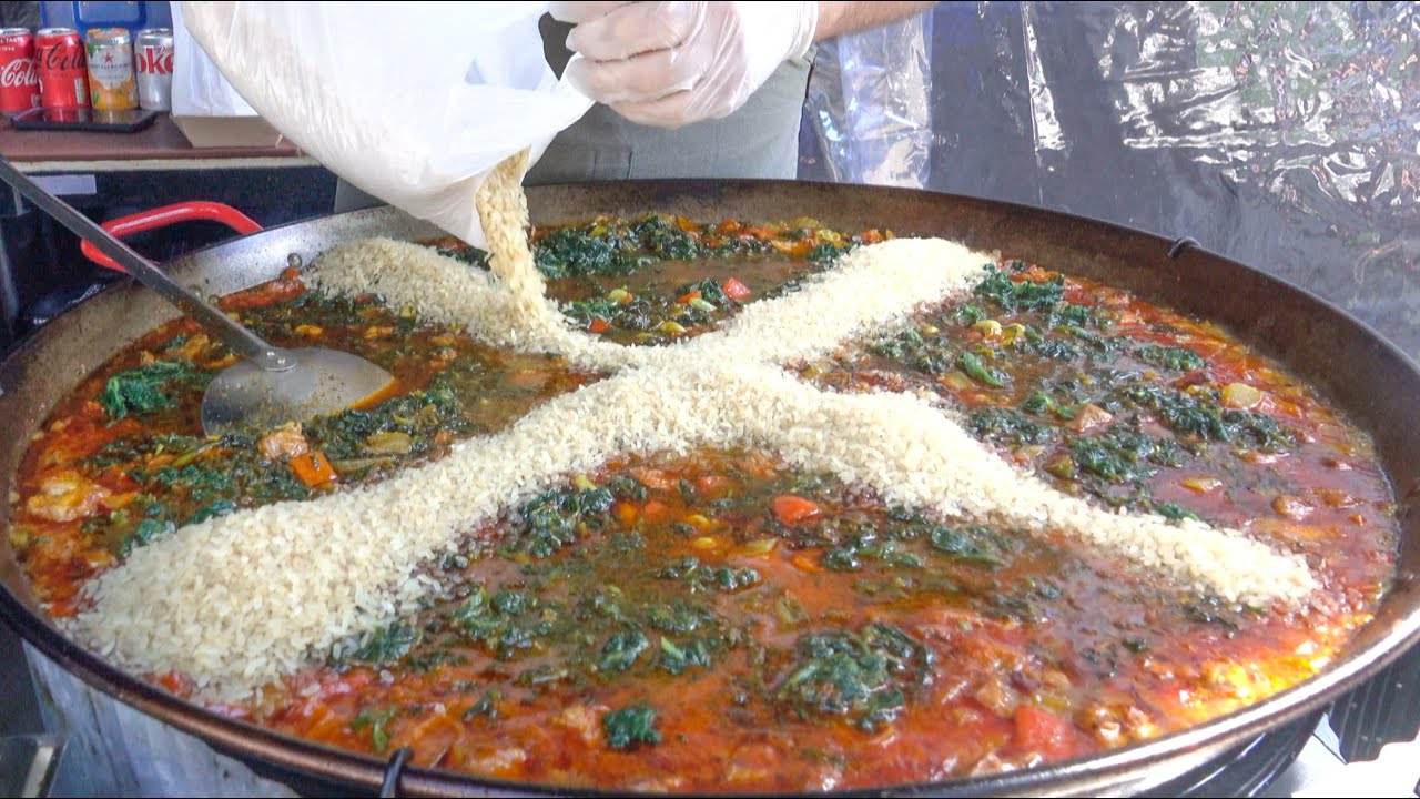 Spanish Paella with Pork, Sausages, Rice and Spinach. London Street Food